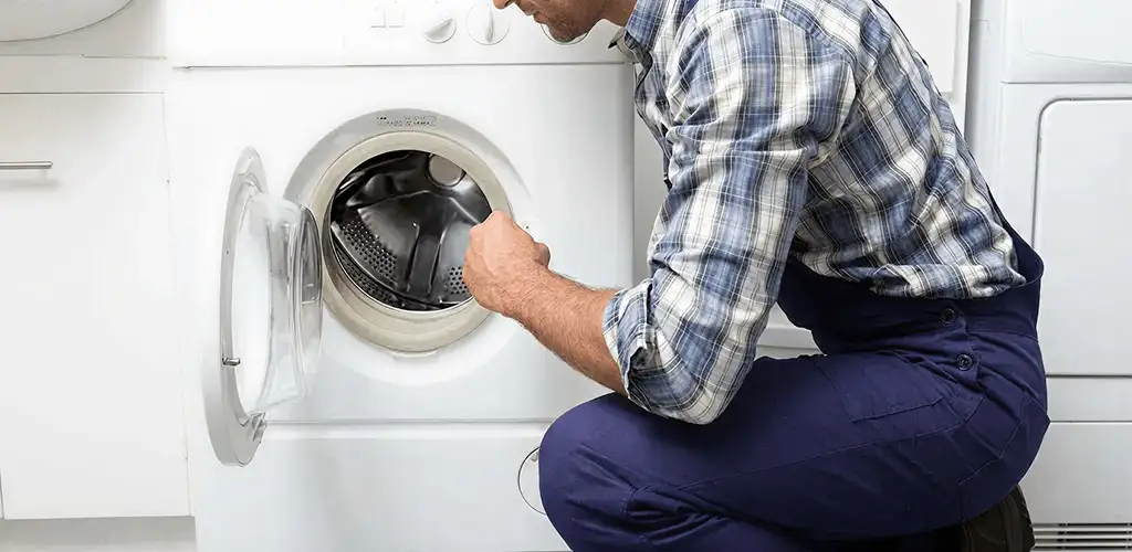 Handyman inspecting a dryer drum and internal parts for repair in Ann Arbor, MI