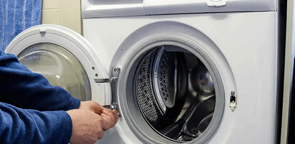 Washing machine repair handyman checking a front-load washer door and latch in Ann Arbor, MI