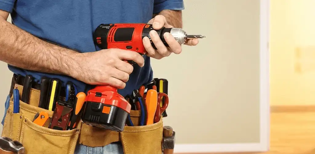 Handyman holding a power drill for home repairs and installations in Ann Arbor, MI