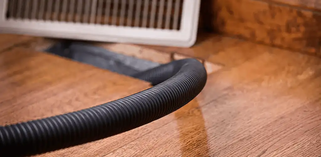Air duct cleaning hose inserted into a floor vent for ductwork cleaning in Ann Arbor, MI